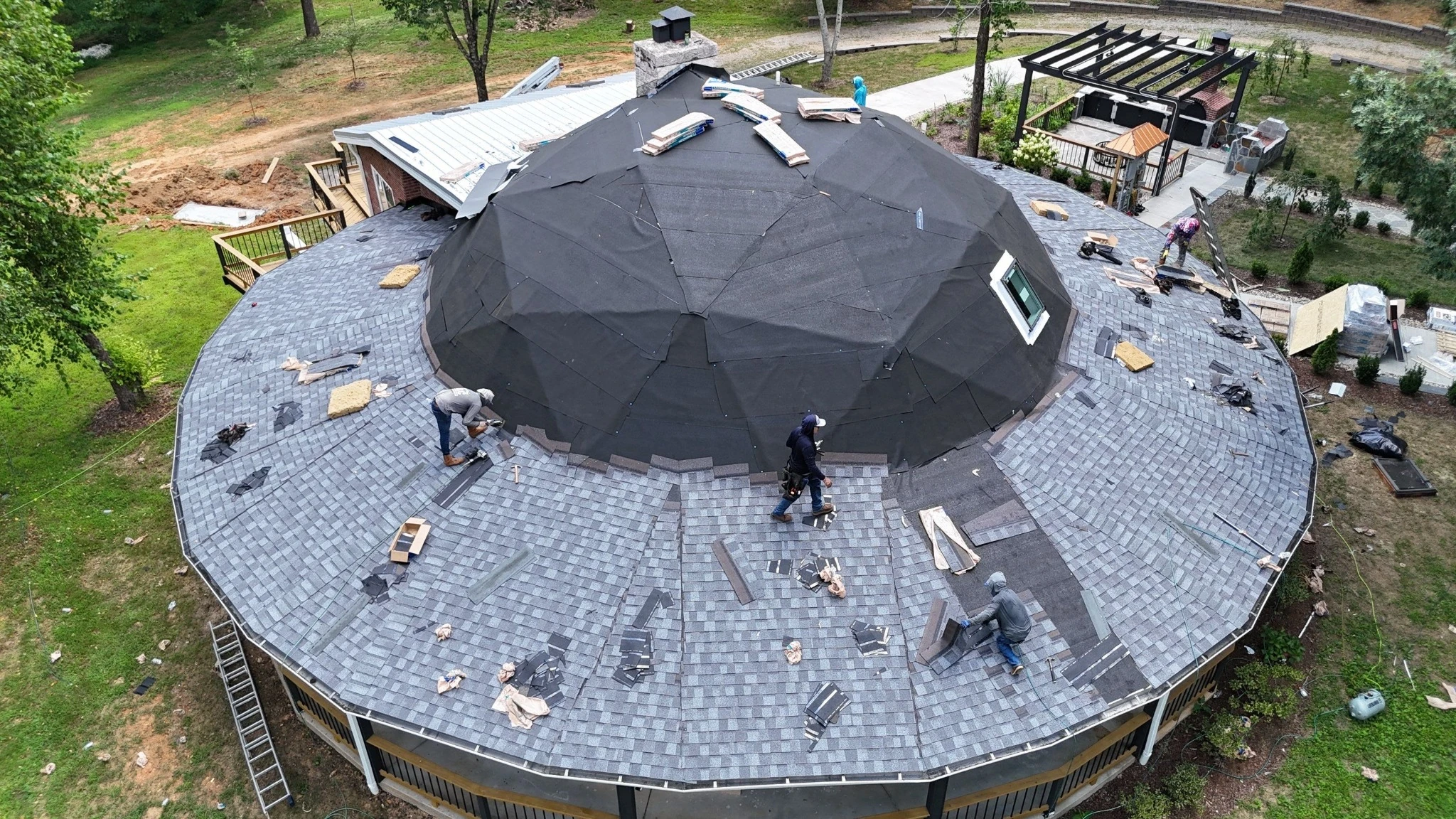 Crew installing shingles on an intricate multi-hip roof in Fairview, TN