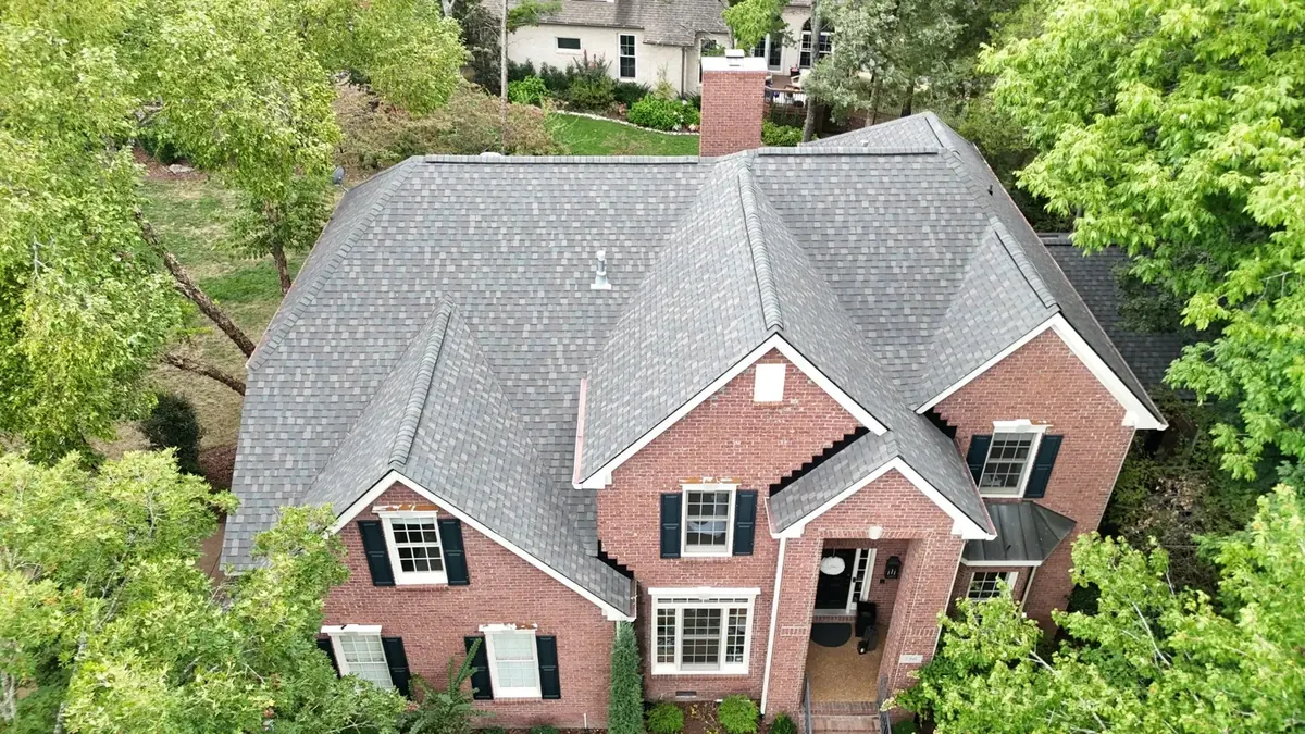 Completed new roof installation on a two-story red brick home